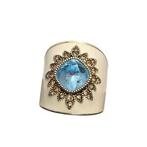Beautiful cream and gold ring with vibrant blue stone.